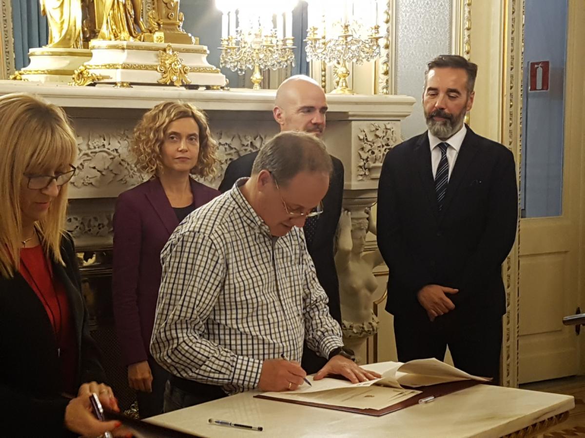 Firma del acuerdo por CCOO (José Manuel Vera, secretario general de CCOO en la AGE), detrás, la ministra Meritxel Batet
